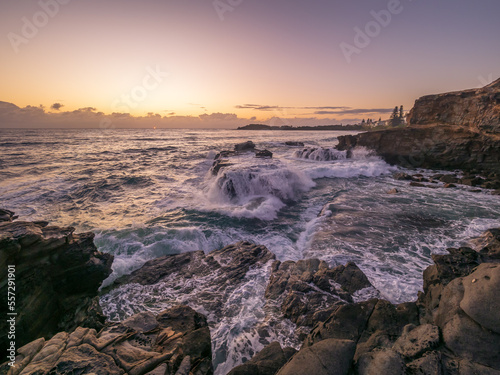 Coastal Sunrise with Waves Crashing on Rocks