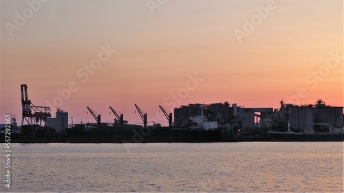 赤く染まる空と対岸の巨大工場のシルエット © 雑猫
