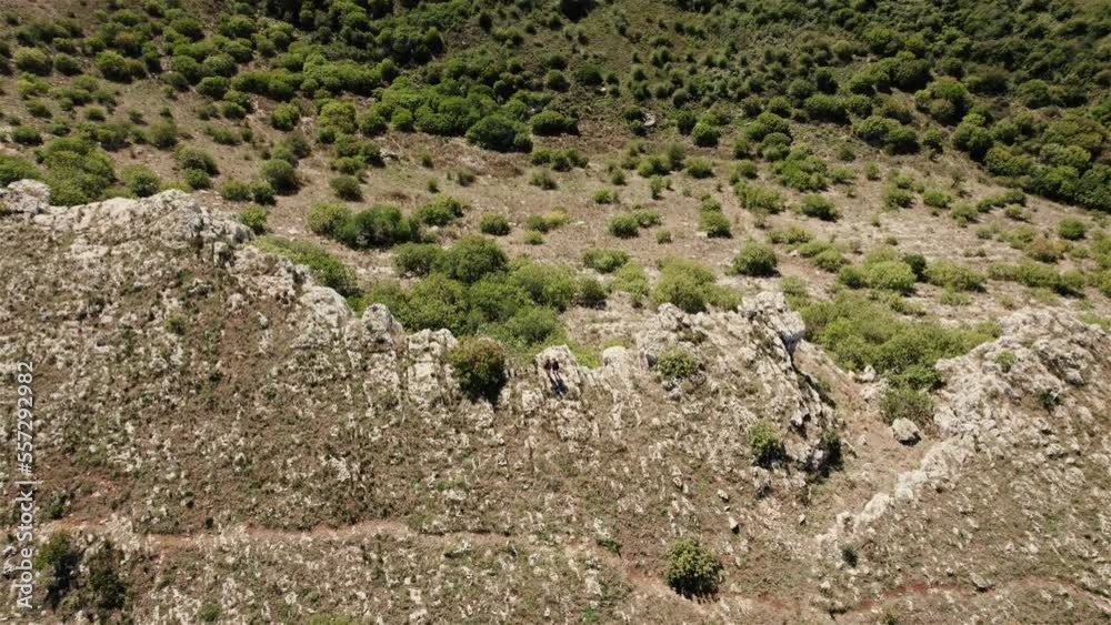 drone flying backwards with the camera tilting up filming 2 persons standing on the edge of a large crater in 4k drone flying backwards with the camera tilting up filming 2 persons standing on the edge of a large crater in 4k
