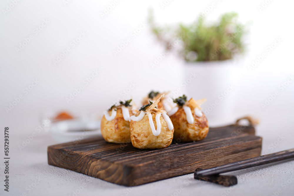 Takoyaki is Japanese Street Food containing with octopus, sausage or cheese. garnish with seaweed and katsuobushi