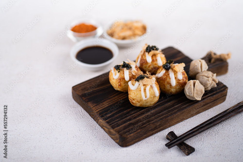 Takoyaki is Japanese Street Food containing with octopus, sausage or cheese. garnish with seaweed and katsuobushi