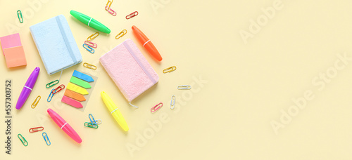 Set of different bright stationery on light yellow background with space for text