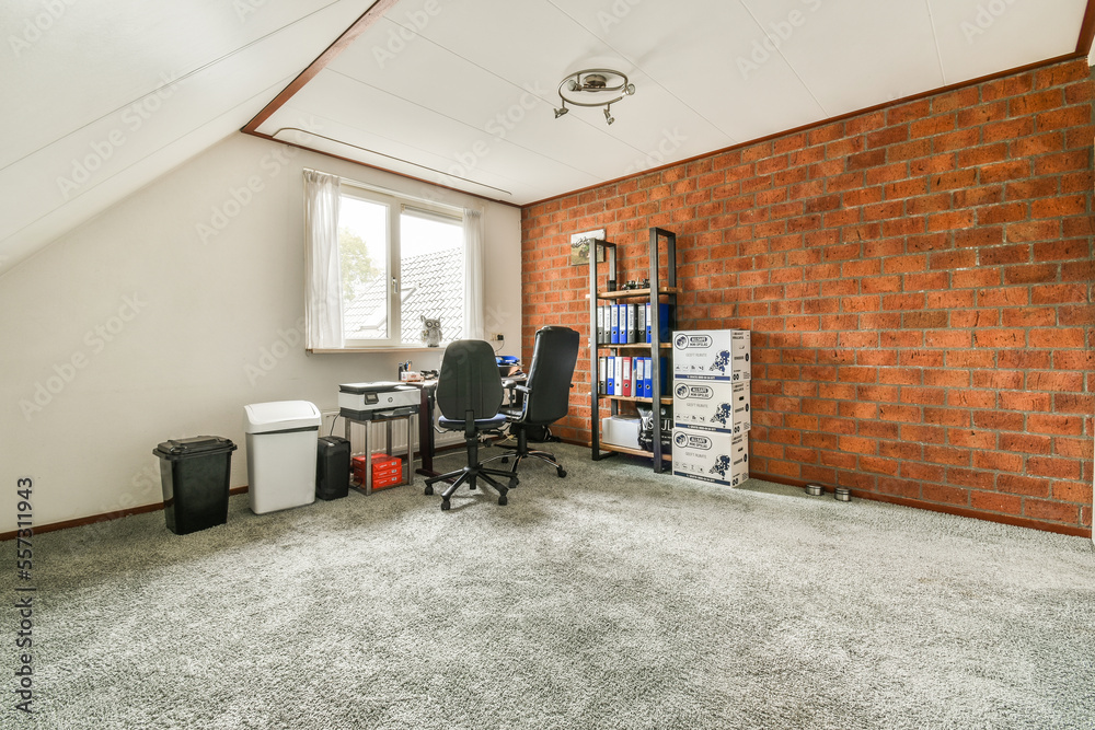 Obraz premium a room with a brick wall and an office chair in the corner, next to a computer on a desk