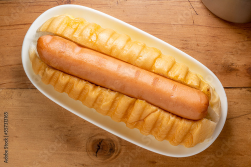 A hot dog, Bun with grilled sausage served on white plate for breakfast or appetizer dish.