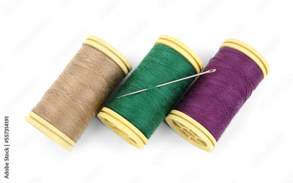 Sewing thread spools with needle on white background Sewing thread spools with needle on white background