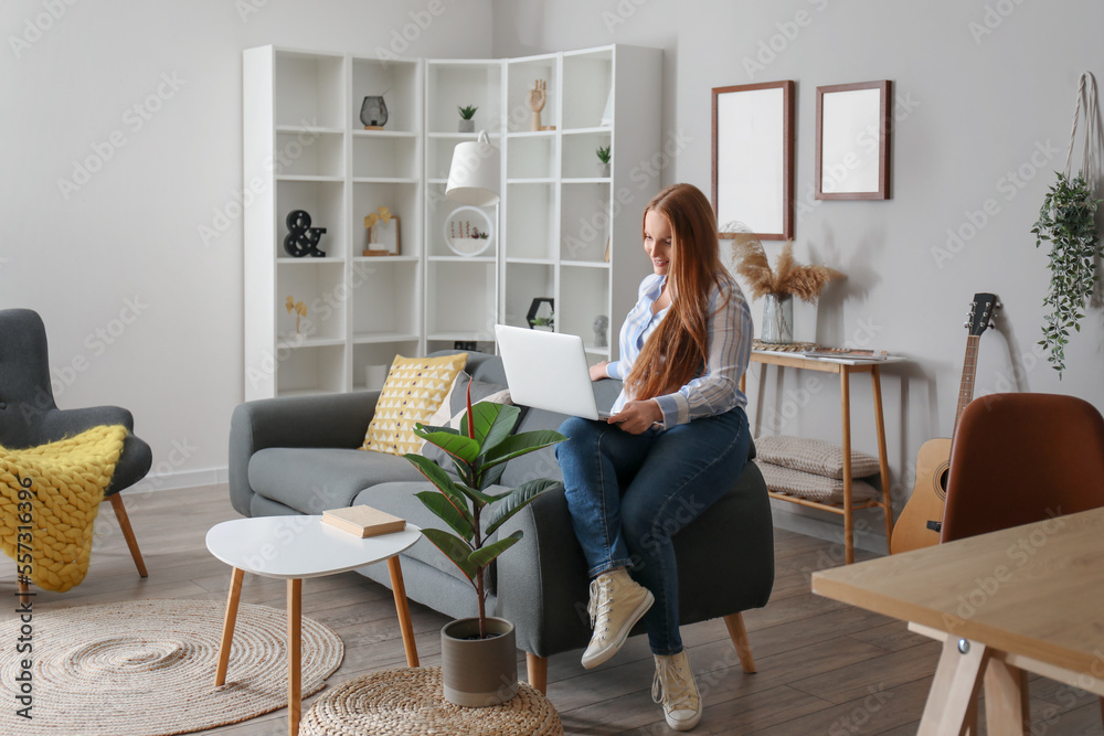 Beautiful woman using laptop on black sofa at home Beautiful woman using laptop on black sofa at home