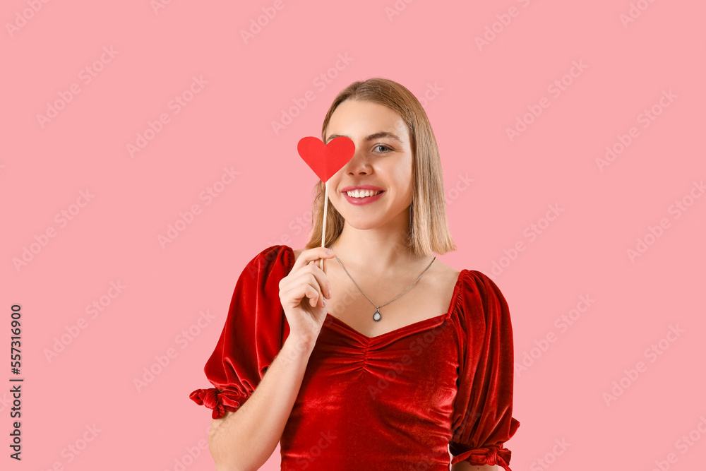 Young woman with paper heart on pink background. Valentine's Day celebration Young woman with paper heart on pink background. Valentine's Day celebration