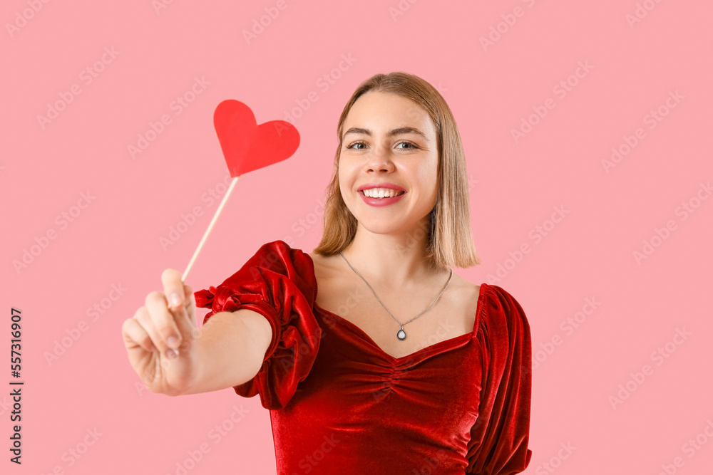 Young woman with paper heart on pink background. Valentine's Day celebration Young woman with paper heart on pink background. Valentine's Day celebration