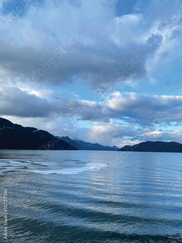 A sunny winter afternoon in Harrison Hot Springs, British Columbia, Canada. Blue sky, white cloudy, and beautiful reflection. Some waves and thin ice on the lake surface. © Yeh