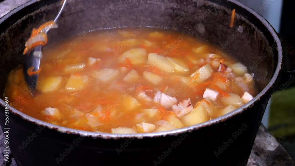cooking in a cauldron preparing food on the stove close-up cooking in a cauldron preparing food on the stove close-up