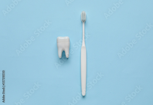 Plastic tooth with brush on blue background