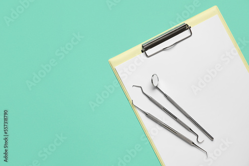 Dental tools with clipboard on green background