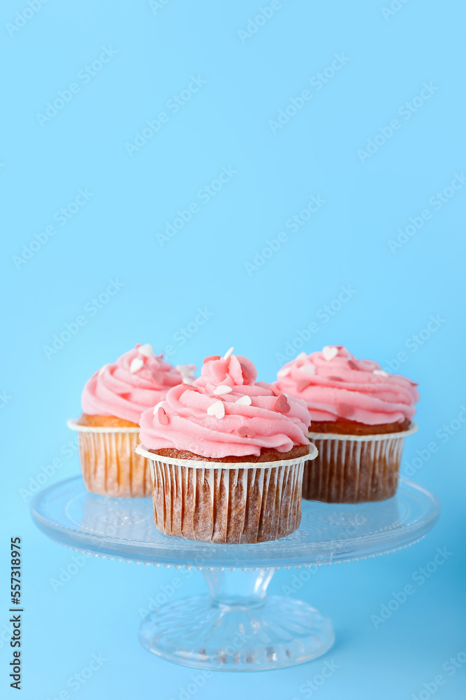 Glass stand with cupcakes for Valentine's Day on blue background Glass stand with cupcakes for Valentine's Day on blue background