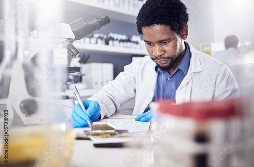 Black man writing report for science study  scientist in lab for research to test and experiment for scientific innovation. Biotechnology in laboratory  focus and knowledge  pen and checklist.