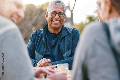 Happy, chess or couple of friends in nature playing a board game, bonding or talking about a funny story. Park, support or healthy senior people laughing at a joke and enjoying quality relaxing time