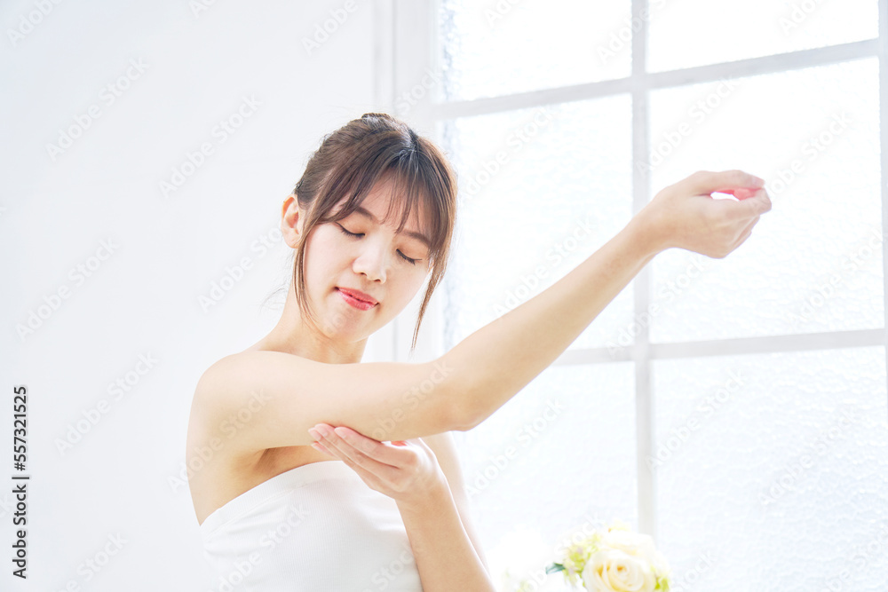 家で二の腕を摘む女性