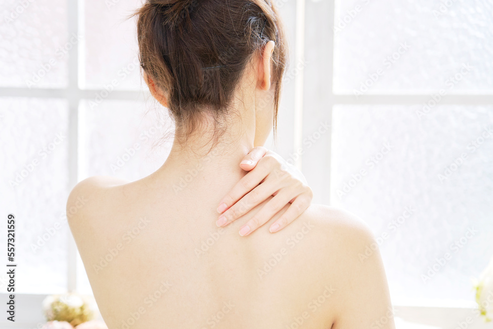 背中のスキンケアをする女性 後ろ姿 背中のスキンケアをする女性 後ろ姿