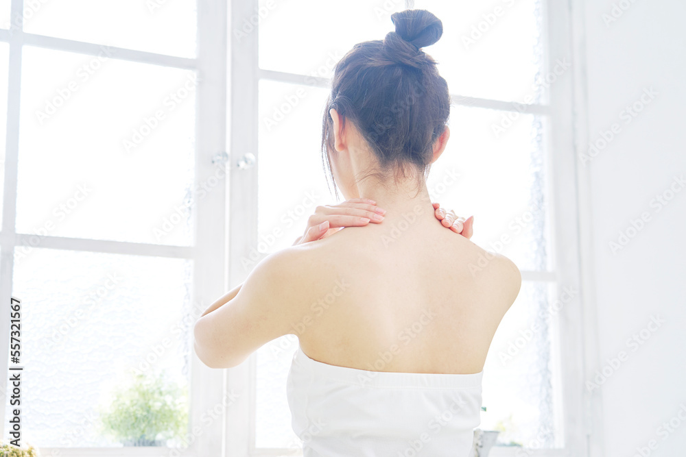 背中のスキンケアをする女性 後ろ姿 背中のスキンケアをする女性 後ろ姿
