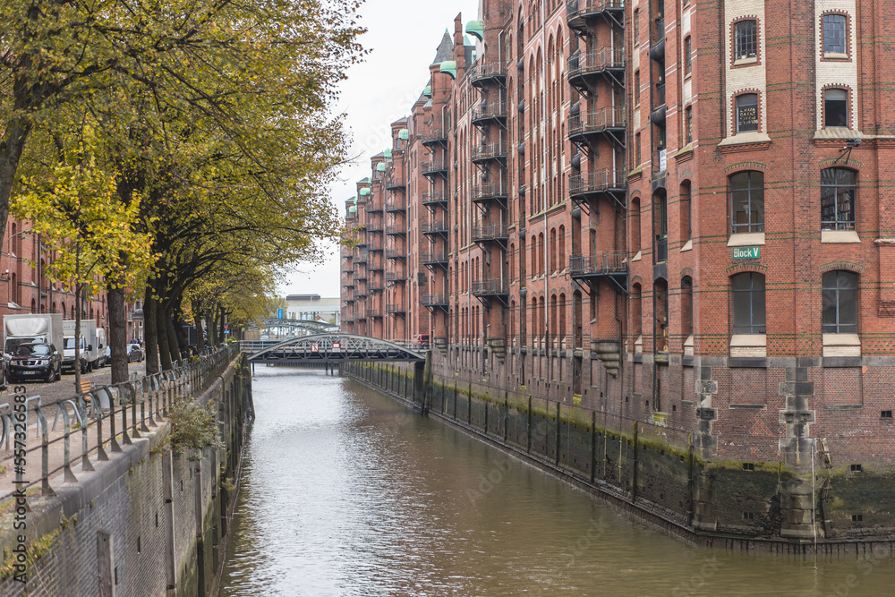 Canal and bridge over it connecting the street and red brick building. Hamburg, Germany