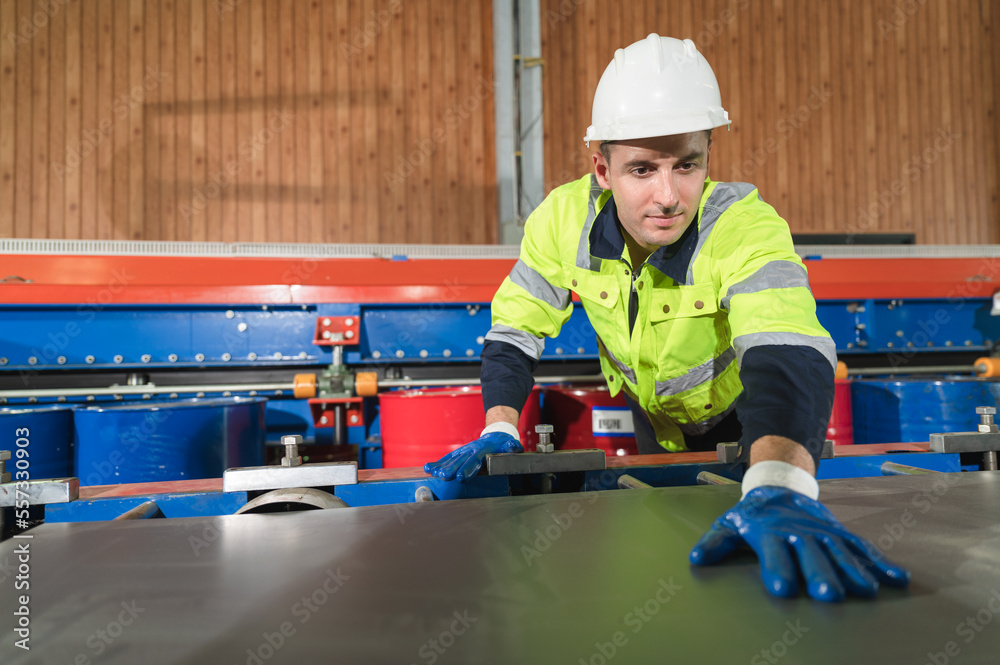 Portrait caucasian engineer checking machine at metal sheet factory Portrait caucasian engineer checking machine at metal sheet factory