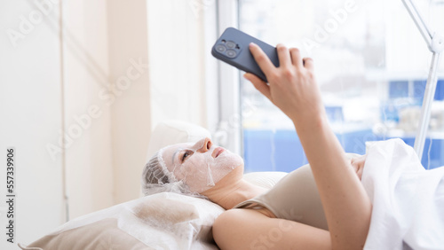 The client takes a selfie on the phone in the spa.