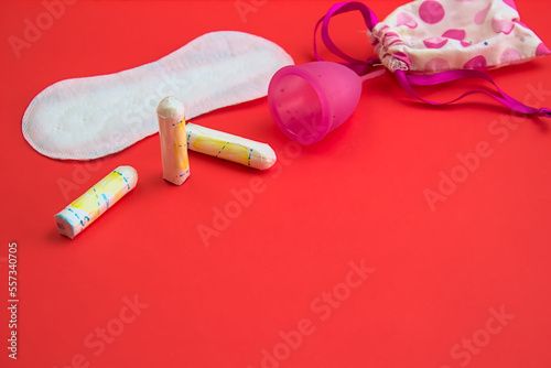 Woman's period equipment on red background