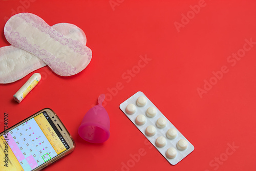 Woman's period equipment on red background