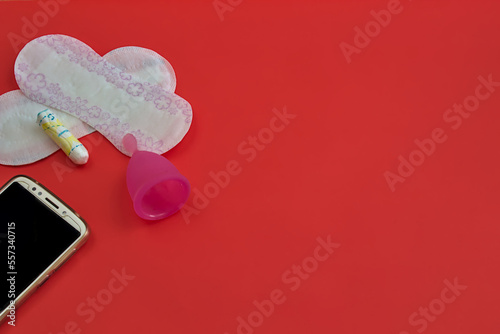 Woman's period equipment on red background