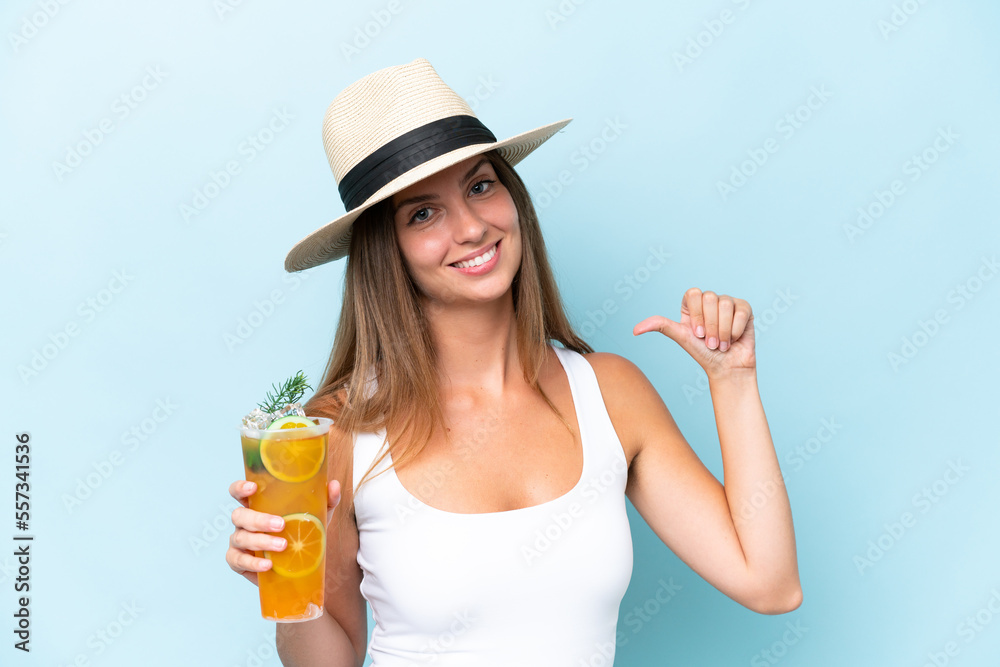 Young beautiful woman holding a cocktail isolated on blue background proud and self-satisfied Young beautiful woman holding a cocktail isolated on blue background proud and self-satisfied