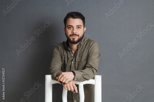 corporate portrait of businessman, young caucasian man leaning on chair