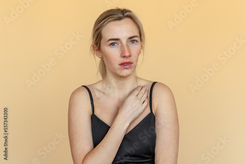 Young woman suffering from severe depression, anxiety, sadness, crying, standing over beige background. Unhappy girl feeling lonely and depressed, thinking about relationship or personal problems