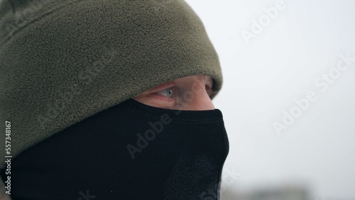 Canvas Print Close-up portrait of a soldier in a winter hat and balaclava
