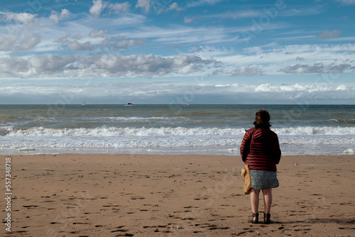 Fényképezés Femme debout sur la plage de Trouville, Normandie.