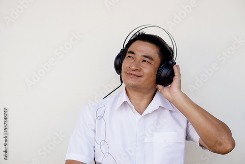 Handsome Asian man listens to music from headphone. Concept, relax time with music and songs.  © Sanhanat