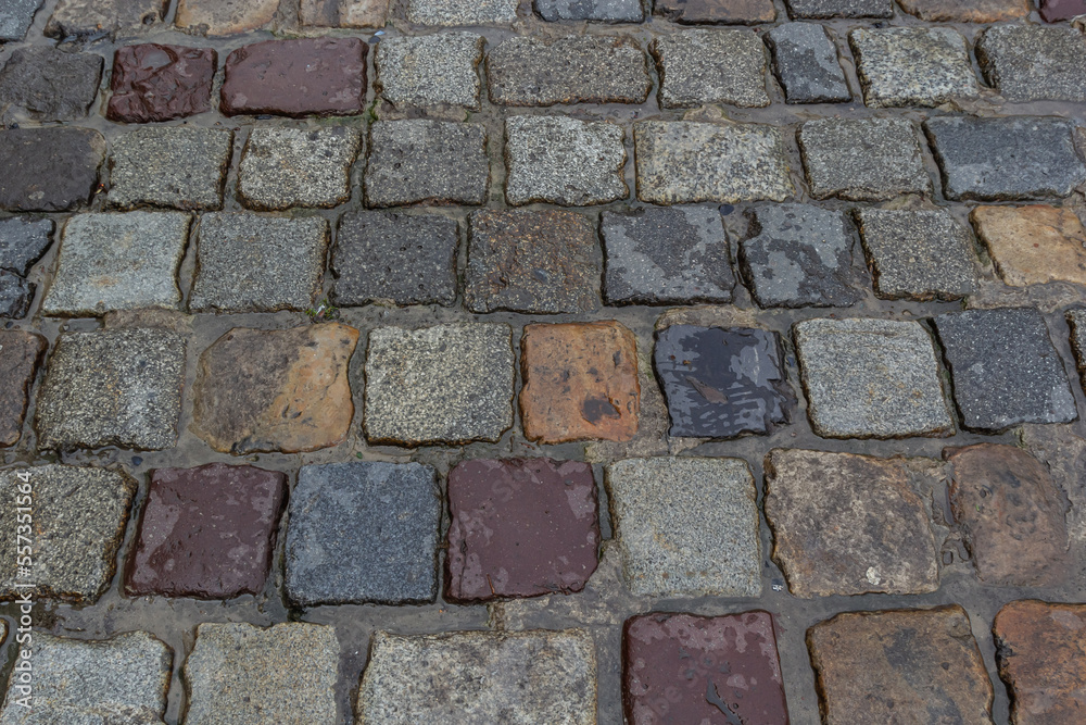 Granite dirty paving stones in the city. Road from paving stones for background and texture. The old road of granite paving stones Granite dirty paving stones in the city. Road from paving stones for background and texture. The old road of granite paving stones