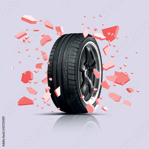 A wheel with a cast disk among stone fragments. Wall explosion. Sports car wheel tread. Tyre wheel rubber.