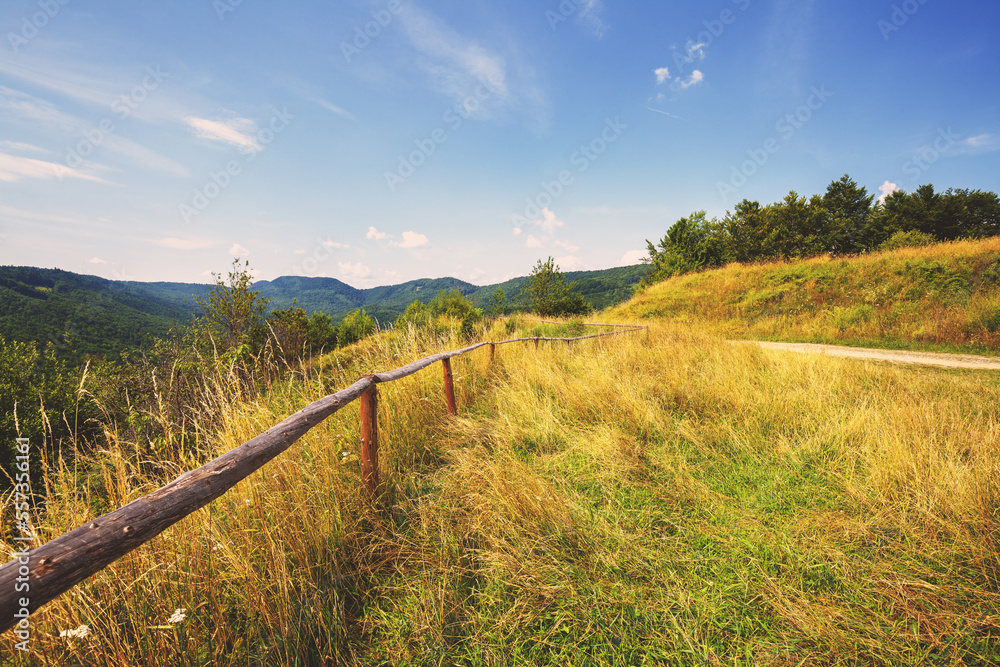 Wooden fence on the mountainside. Mountain landscape in autumn on a sunny day