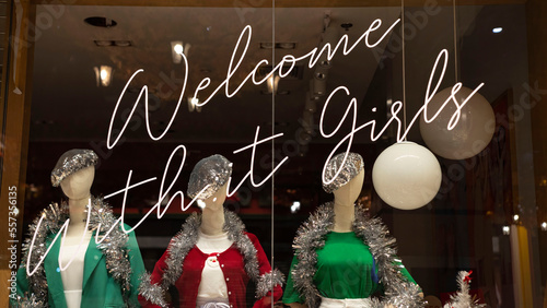 Three dressed female mannequins behind a showcase with an inscription photo