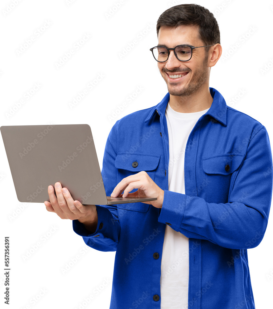 Young stylish man wearing casual blue shirt, standing with opened laptop, surfing online or typing Young stylish man wearing casual blue shirt, standing with opened laptop, surfing online or typing