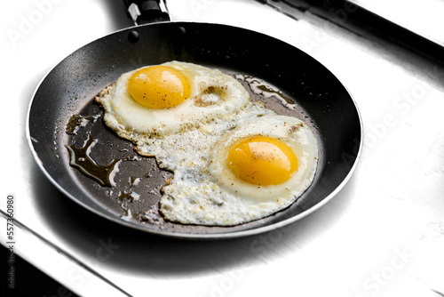 close-up shot of fried eggs on black pan