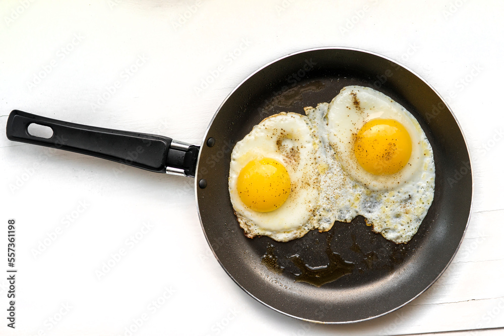 close-up shot of fried eggs on black pan close-up shot of fried eggs on black pan