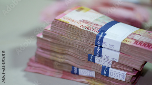 a pile of 100 thousand rupiah denominations, a pile of rupiah bills, Indonesian rupiahs, banknotes photo