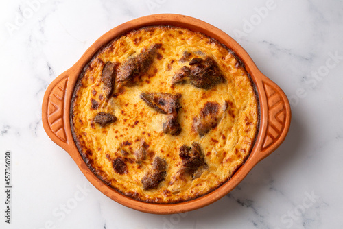 Tave kosi is a national Albanian dish of baked lamb and rice with yoghurt close-up in a pan on the table. horizontal top view from above. Turkish name; Elbasan tava photo