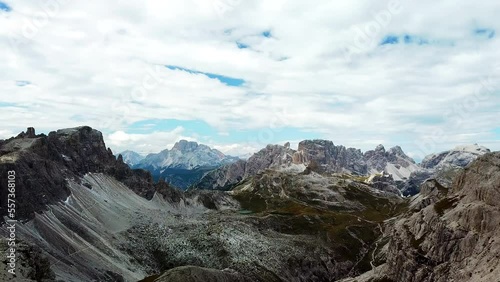 An endless view on a high desolated mountain peaks in Italian Dolomites, South Tyrol (Alto Adige), Italy, Europe. Idyllic hiking trail to Oberbachernspitz. Raw unspoiled landscape. Cloud covered sky