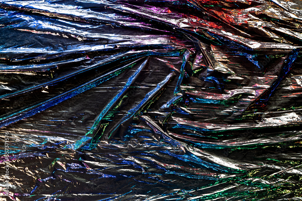 Black color plastic wrap background. Dark crumpled wrinkled plastic