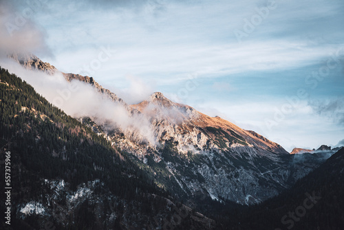 Mountains covered in misty clouds against blue sky