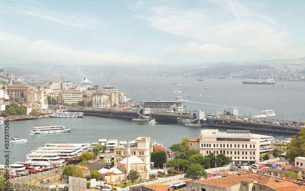 Aerial view of Golden Horn, with Galata Bridge and Karakoy Ferry Terminal with ferry boat approaching the terminal, and Bosphorus bridge in the far end, Istanbul, Turkey