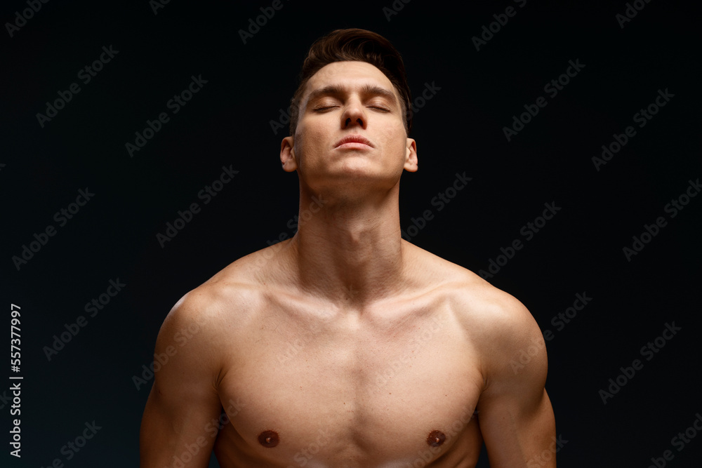 Image of handsome concentrated man standing naked isolated over black wall background Stock-Foto