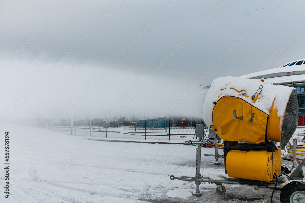Snow cannons spray artificial snow crystals. Production of artificial snow. Cars make snow.