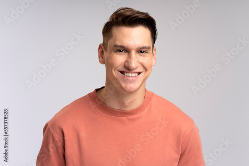 Portrait of happy successful caucasian man standing, looking at camera with positive smile